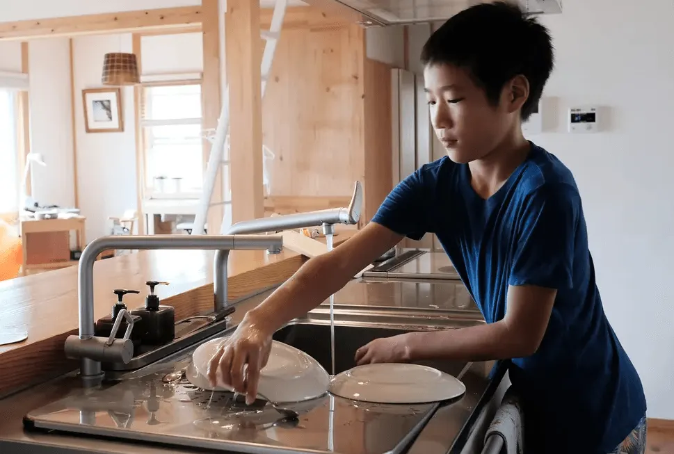 A child washing dishes